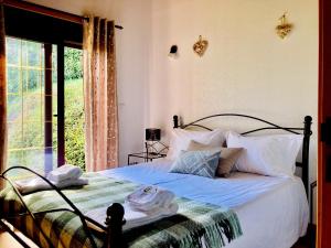 una camera da letto con un letto e una grande finestra di Casa do Caminho do Monte a Arcos de Valdevez Altre 46 foto