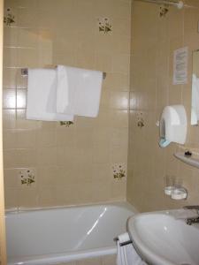 a bathroom with a bath tub and a sink at Alpenhotel in Oetz