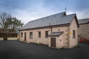 a large brick building with a parking lot at Drumgart Self Catering Cottage in Carrickfergus