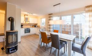 a kitchen and dining room with a table and a wood stove at Seeadler - a26427 in Zingst