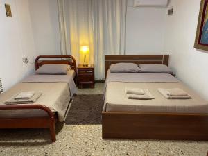2 camas en un dormitorio con una lámpara en una mesa en Omodos Village Houses, en Omodos
