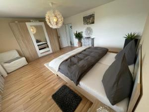 Un dormitorio con una cama grande y una lámpara de araña. en Adonde, en Neuried