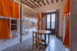 a room with a table and bunk beds at El Albergue de Sigüenza in Sigüenza