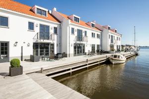 a group of buildings with a boat in the water at Najade Resort in Loosdrecht