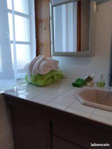 a towel sitting on a bathroom counter next to a sink at Gîte La petite maison horlogère et jacuzzi , raquettes in Les Fontenelles