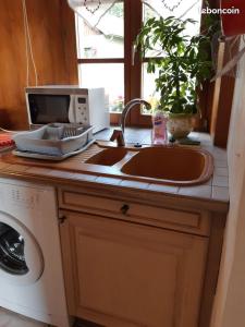 a kitchen counter with a sink and a computer on it at Gîte La petite maison horlogère et jacuzzi , raquettes in Les Fontenelles