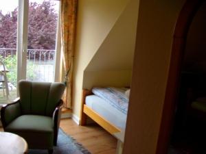 ハイリゲンハーフェンにあるFerienwohnung mit Ostseeblickのベッドルーム1室(ベッド1台、椅子、窓付)