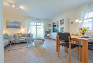 ein Wohnzimmer mit einem Tisch und einem Esszimmer in der Unterkunft Haus Bullerbü in Zingst