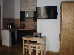 a kitchen with a small table and a tv on the wall at Le Saint André in Villeneuve-lès-Avignon