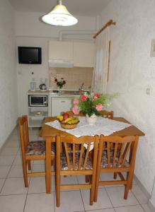 una cocina con una mesa con un bol de fruta. en Prasoudopetra en Ágios Matthaíos