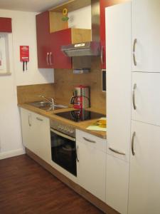 a small kitchen with white cabinets and a sink at Fewo im Kastania Nr19 in Petersdorf auf Fehmarn