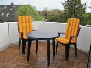 2 sillas y una mesa en el balcón en Fewo im Kastania Nr19, en Petersdorf auf Fehmarn