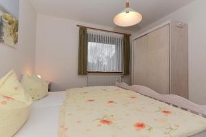 a bedroom with a bed with a floral bedspread at Schleswig-Holstein Whg 01 EG li in Nieblum