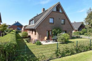 a brick house with a fence in front of it at Schleswig-Holstein Whg 01 EG li in Nieblum