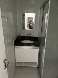 a man taking a picture of a bathroom sink at victory flat em Intermares in Cabedelo