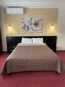 1 dormitorio con 1 cama grande y 2 cuadros en la pared en Hotel Merry Club en Malyye Khutora