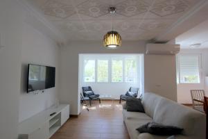 salon z kanapą i telewizorem w obiekcie Apartamento Mercedes Céntrico Playa w mieście Sanlúcar de Barrameda