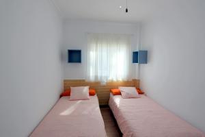 dwa łóżka w pokoju z oknem w obiekcie Apartamento Mercedes Céntrico Playa w mieście Sanlúcar de Barrameda