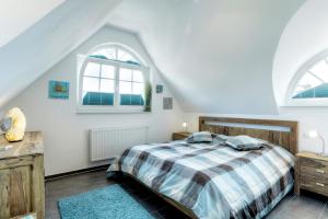 a bedroom with a bed and two windows at Villa Obendtied, DG-Wohnung "Reet" FW 6 in Zingst