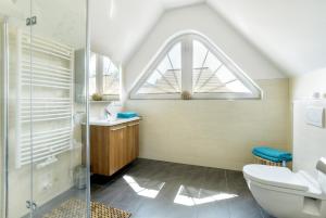 a bathroom with a toilet and a sink and a window at Villa Obendtied, DG-Wohnung "Reet" FW 6 in Zingst