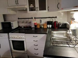une cuisine avec des placards blancs et un comptoir noir dans l'établissement barnApartman, à Eger