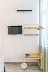 Habitación con TV en la pared y escritorio. en Giorgio I rooms, en Palermo 55 fotos más