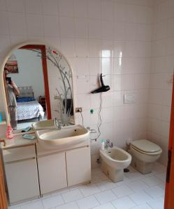 a bathroom with a sink and a toilet and a mirror at VILLA ELENA in Vico Equense