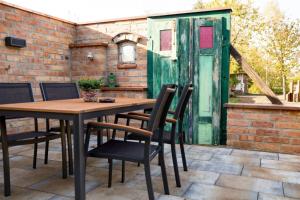 a patio with a table and chairs and a green door at Ferienwohnung 3 in Hoyerswerda