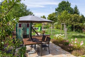 a table and chairs under an umbrella in a garden at Ferienwohnung 3 in Hoyerswerda