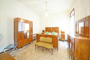 a room with a bed and a dresser and a chair at DolceVita Apartments N. 490 in Venice