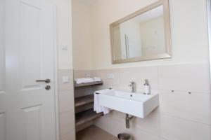 een witte badkamer met een wastafel en een spiegel bij Herrmannshof Haby App 1 Arnis in Haby