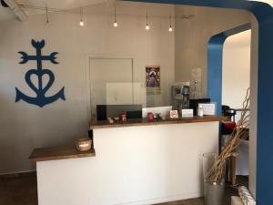 a room with a counter with a blue anchor on the wall at Hotel Le Bleu Marine in Saintes-Maries-de-la-Mer