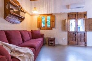 Encantadora casa rural con piscina privada في البوسكي: غرفة معيشة مع أريكة أرجوانية وطاولة