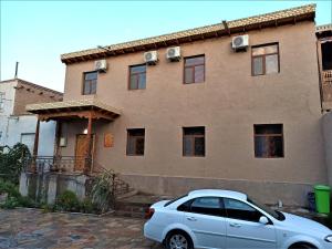 a white car parked in front of a house at Art House Boutique Hotel in Khiva