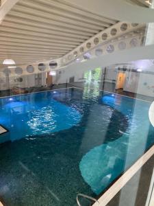 a large swimming pool with blue water in a building at 4 lakes holiday let in Carnforth