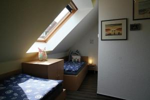 ツィングストにあるAm Deich 23 Strandeule Zingstのベッド2台と窓が備わる小さな客室です。