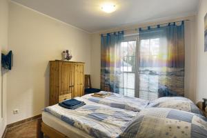 Schlafzimmer mit einem Bett und einem Fenster mit einem Regenbogen in der Unterkunft Nele, Whg 1 in Zingst