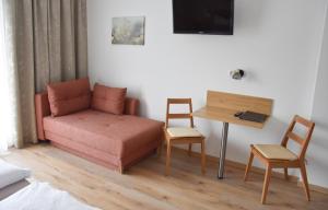 a room with a couch and a table and a desk at Pension Paßler in Seeboden