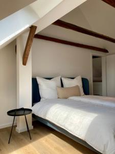 a bedroom with a white bed and a table at Loft an der Seefahrtschule - Timmel in Großefehn 