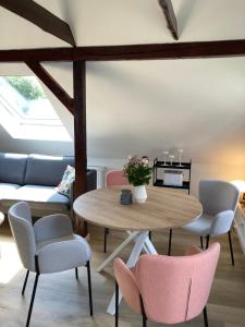 a room with a table and chairs and a couch at Loft an der Seefahrtschule - Timmel in Großefehn  +12 photos