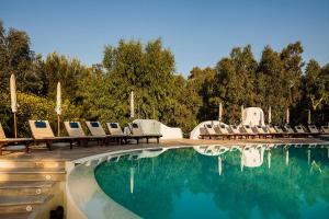 a swimming pool with chairs and a bunch of water at Vulcano Blu Residence in Vulcano