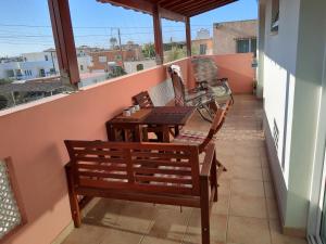 een balkon met 2 stoelen, een tafel en een fiets bij Larnaca Xylophagou 2-bedroom apartment with a shaded terrace in Xylophaghou