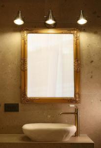 La salle de bains est pourvue d'un lavabo et d'un miroir. dans l'établissement Ares Suites, à Plataria