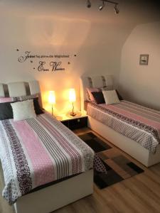 two beds sitting in a room with two lamps at Beti Apartment in Nentershausen