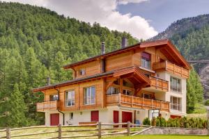 una gran casa de madera en medio de un campo en Apartment Windward, en Zermatt