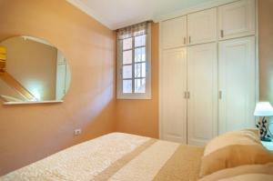 a bedroom with a bed and a mirror at Apartament 1 bedroom Los Cristianos Las Vistas beach in Los Cristianos