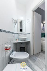 a white bathroom with a sink and a toilet at Giorgio I rooms in Palermo