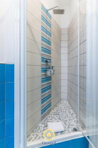 y baño con ducha y azulejos azules y blancos. en Giorgio I rooms, en Palermo