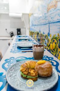 una mesa con una bandeja de donuts y una taza de café en Giorgio I rooms, en Palermo
