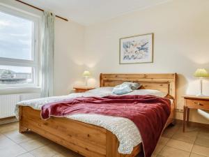 a bedroom with a wooden bed and a window at Ostseeresidenz - Whg 28 in Zingst